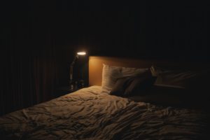 A bed in darkness. The place where you reap the positive effects on your health from sleep.