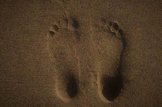 Barfuß im Sand - ein paar Fußspuren beim Erden oder Earthing.